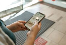 Person browsing a shopping app on a smartphone with product listings visible on screen