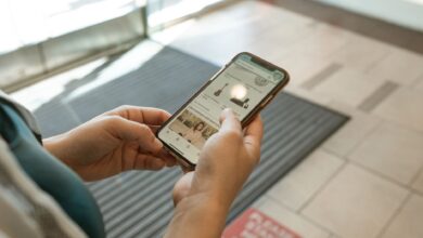 Person browsing a shopping app on a smartphone with product listings visible on screen