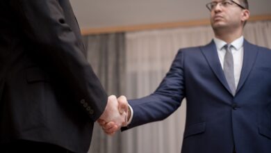 Two business executives reviewing documents at a conference table during a high-stakes negotiation