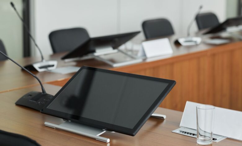 Empty corporate boardroom with large windows and conference table representing executive decision-making