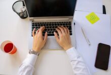 Person working on laptop setting up automated workflows across multiple applications