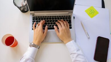Person working on laptop setting up automated workflows across multiple applications