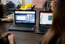 Designer working on a UI layout on a laptop screen in a modern workspace