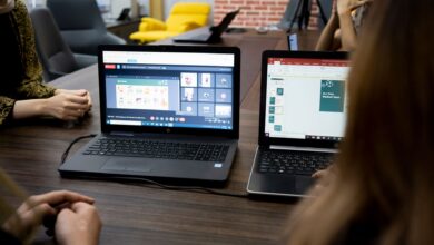 Designer working on a UI layout on a laptop screen in a modern workspace