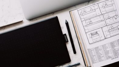 A professional designer working on a laptop with design software open on screen