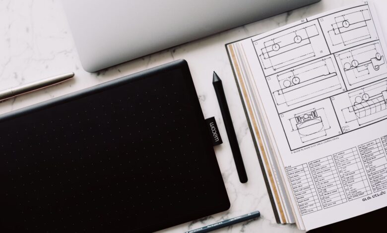 A professional designer working on a laptop with design software open on screen