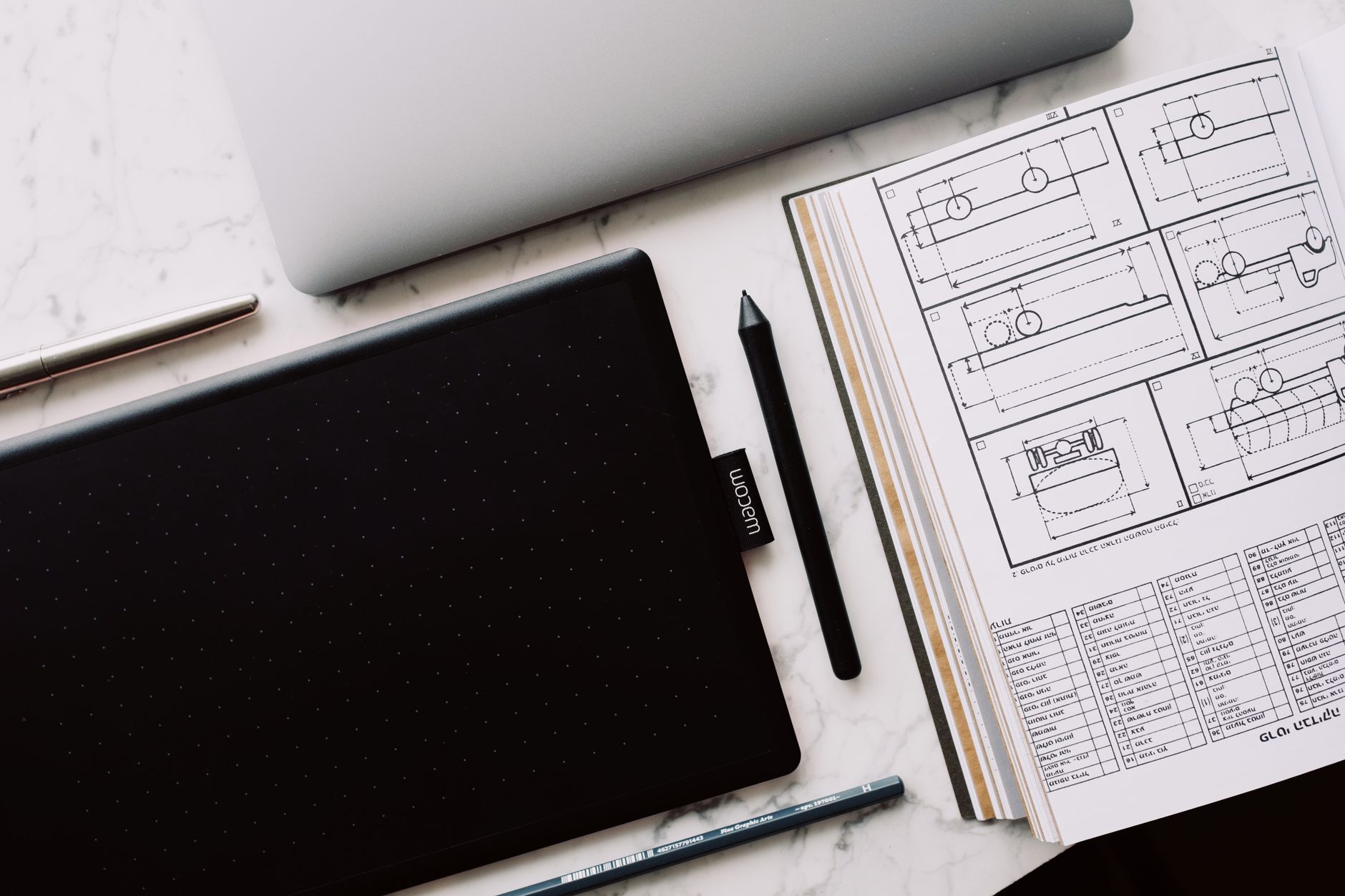 A professional designer working on a laptop with design software open on screen