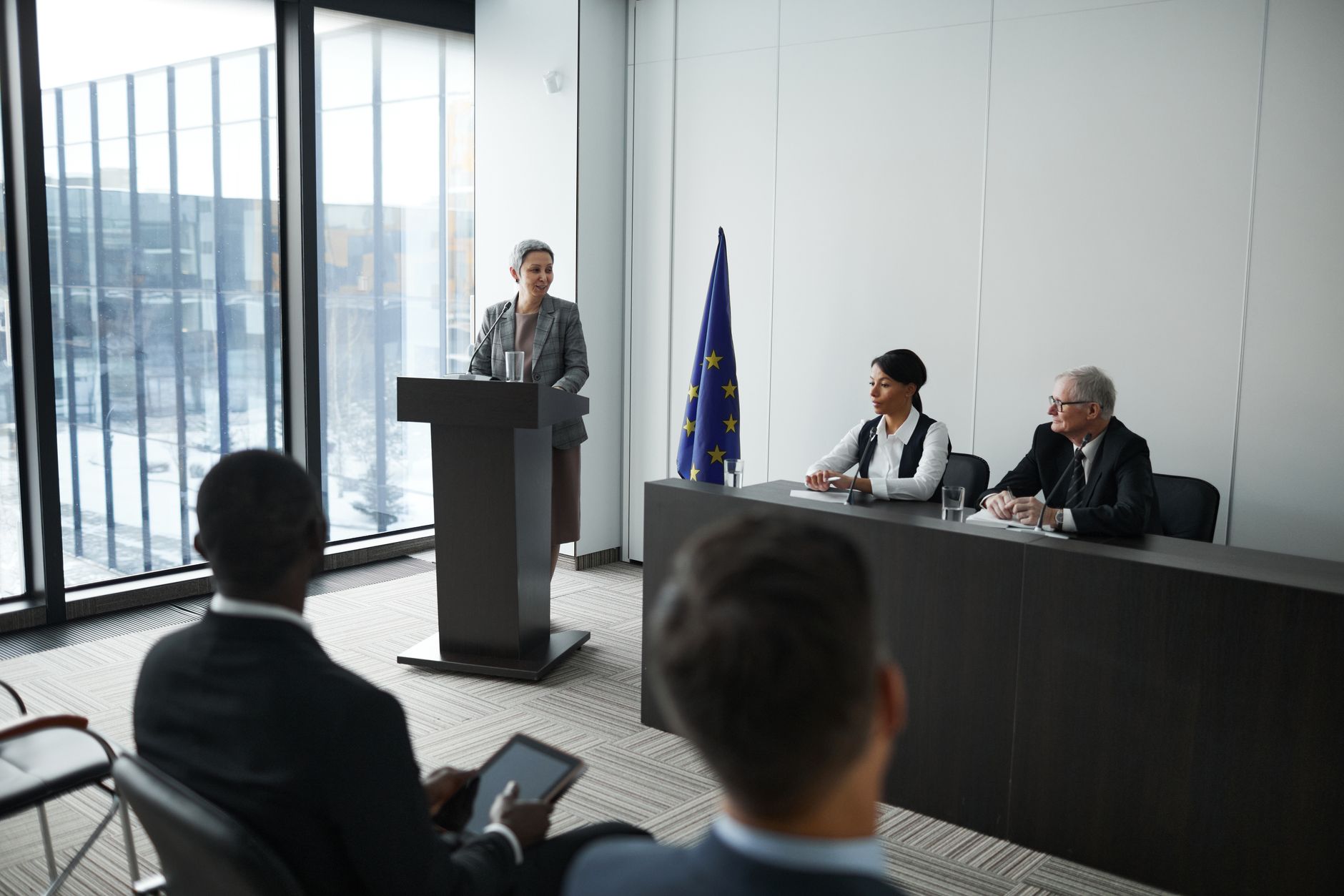 Business executive speaking at a formal podium during a public hearing