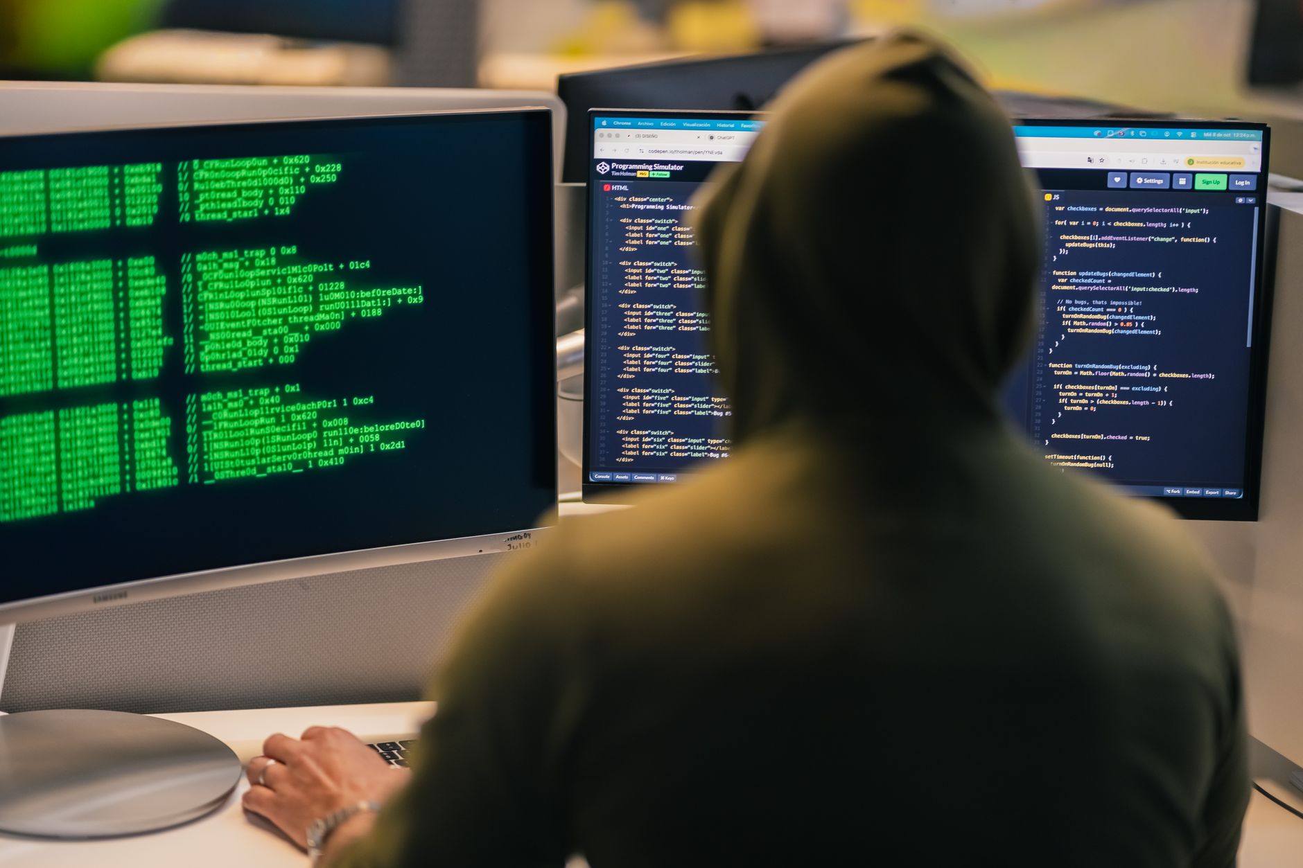 Security analyst working at a computer monitoring cloud threat detection systems