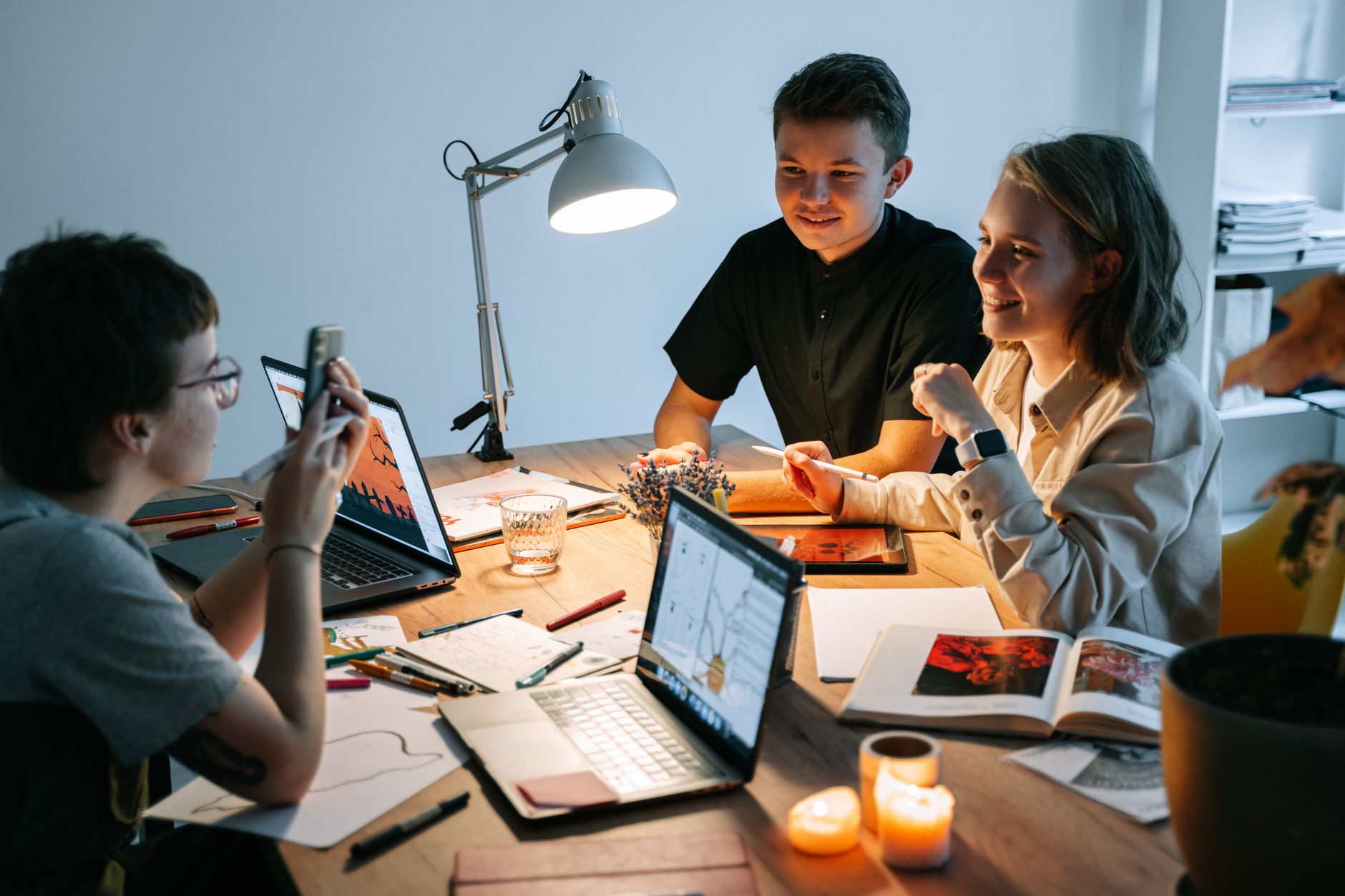 Small creative team collaborating around a screen in a bright office setting